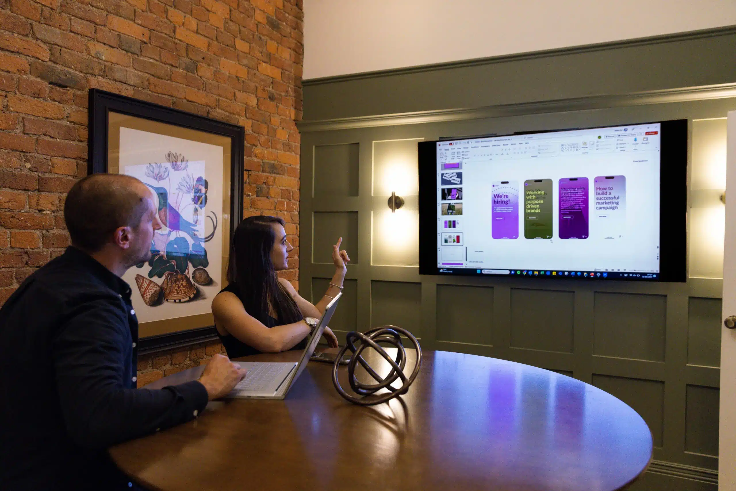 Woman showing something on a TV screen to a man