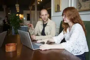 Mike and Georgina in the MP&Co team talking while a laptop is seen showing information about how to focus your marketing