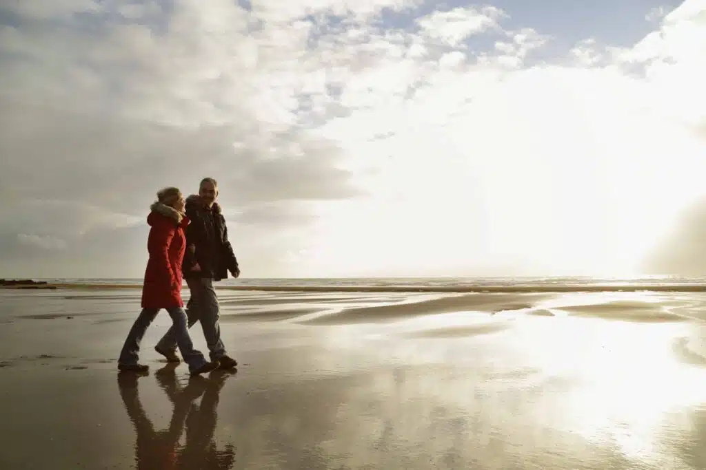 Couple walking on beach , winter, low light.